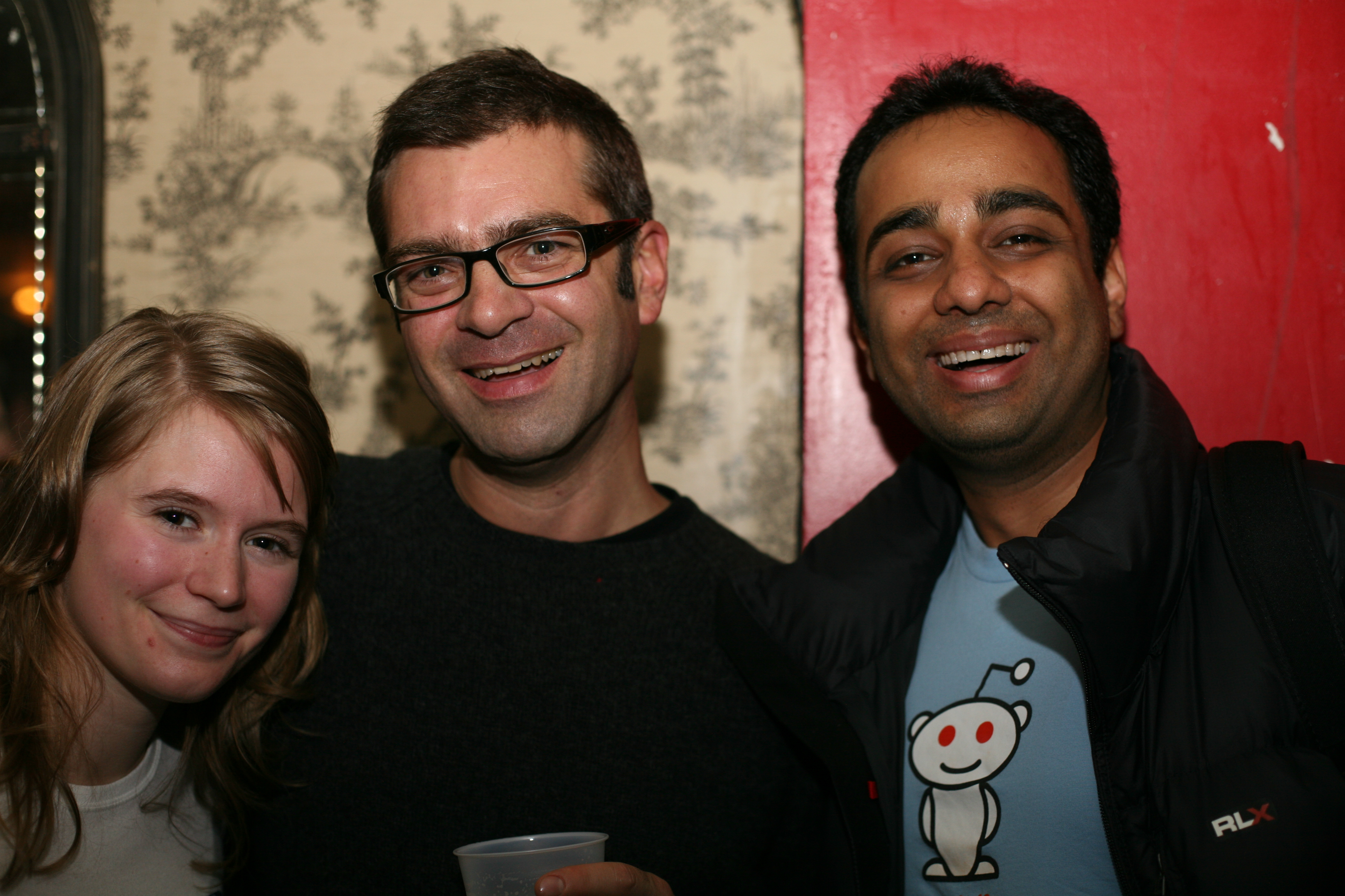 Party guests at the Reddit bar party, one sporting a Reddit alien t-shirt