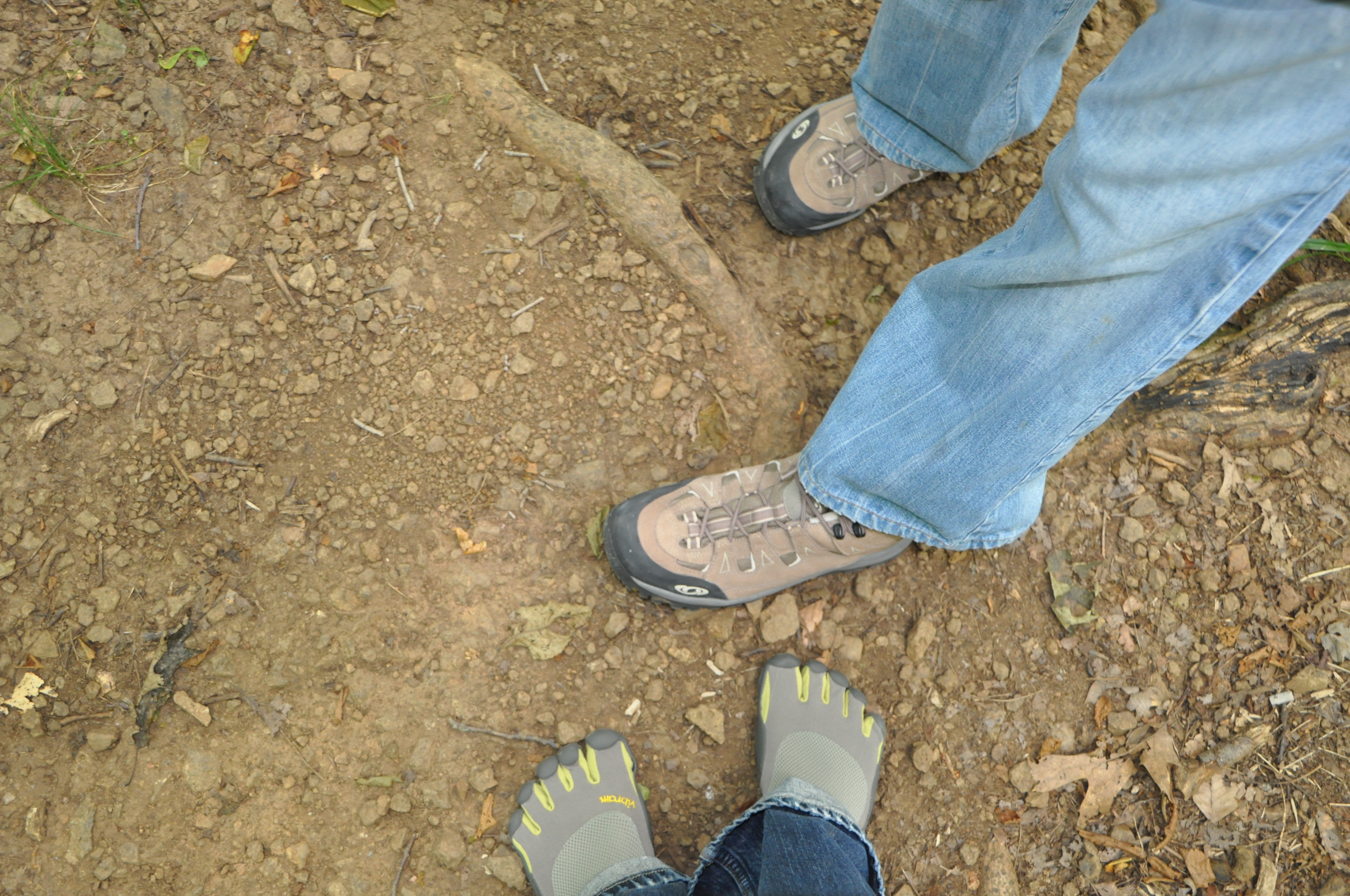 Vibram Five Fingers shoes next to regular hiking shoes on the trail